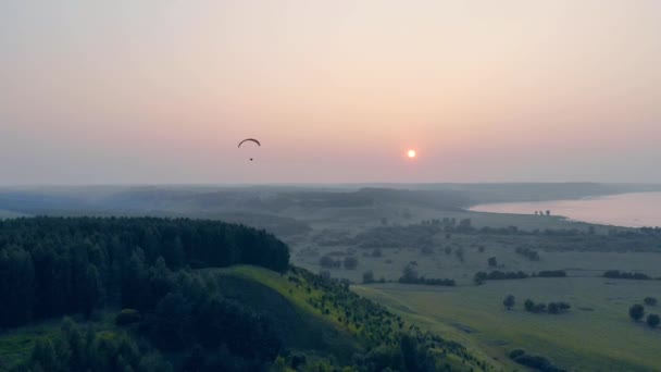 Ram-Air fallskärm driver på himlen medan solen är inställningen — Stockvideo