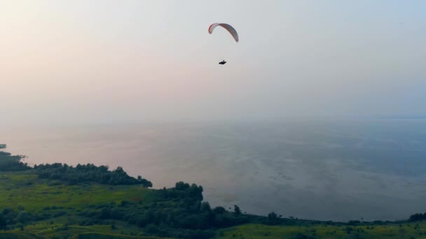 Yelkenci, su ve tarlaların üzerinde gökyüzünde uçuyor. — Stok video