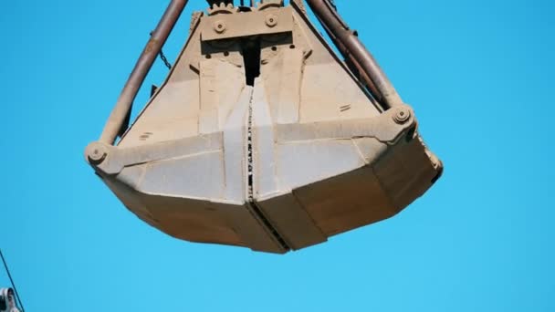 Close-up do balde mecânico com cascalho escavado caindo fora dele — Vídeo de Stock