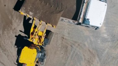 Bir ekskavatör ve bir kamyon bir üst görünümünde dövülen kayalar taşıyor