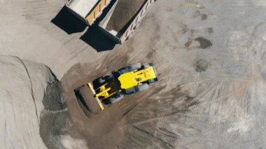 Kazı makinesi kamyonları dövülen kayalarla dolduruyor