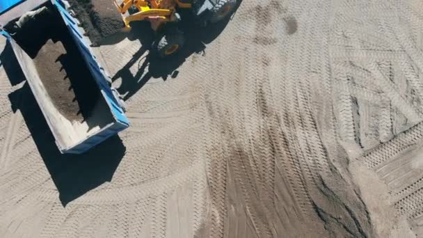 Excavator is pouring pounded rubble into the truck — Stock Video