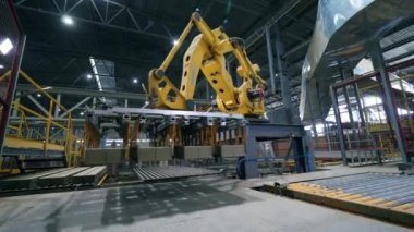 Taşıma ünitesi ve tuğlaların yerini ntaşınan bir yükleme makinesi. Robotik Kol üretim hattı.