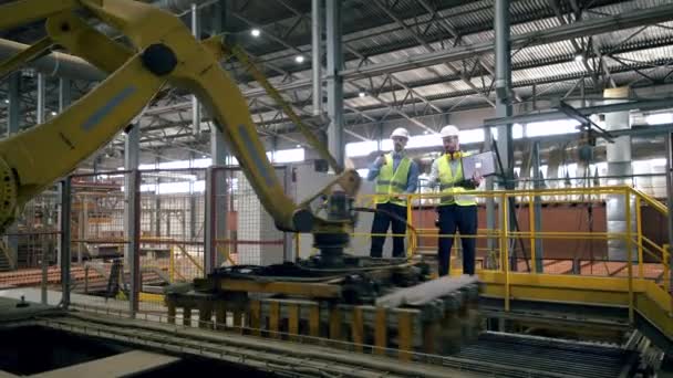 Supervisão do processo de transporte de tijolos realizada por dois engenheiros — Vídeo de Stock