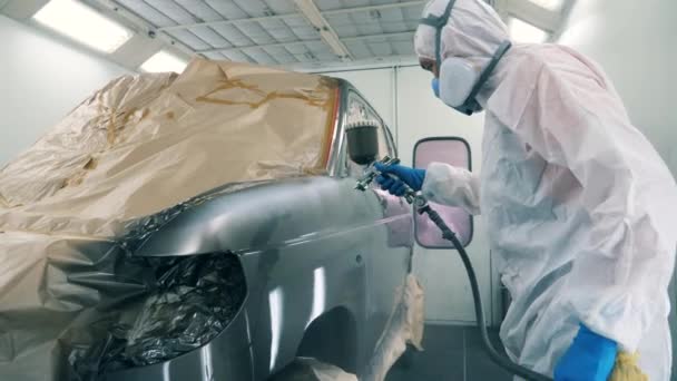 Warsztat i pracownik płci męskiej zabarwienie samochodu. Przemysłowy proces malowania natryskowego. — Wideo stockowe