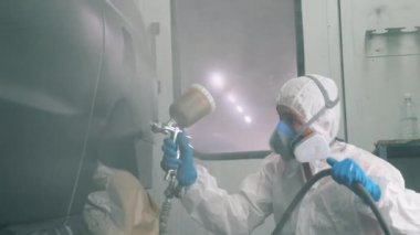 Araba garajda işçi tarafından boyanıyor.