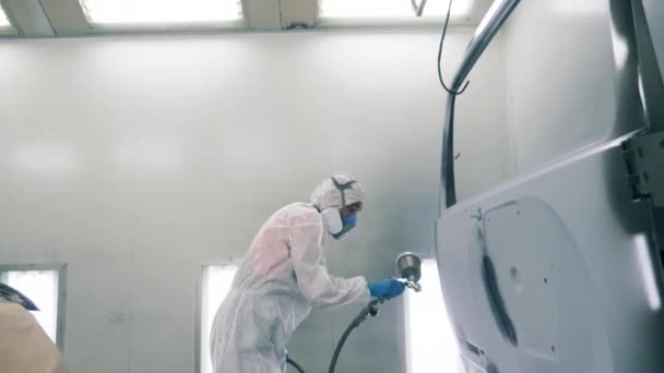 El técnico masculino es la puerta de los coches de pintura al aire. Proceso de pintura en spray industrial . — Vídeo de stock