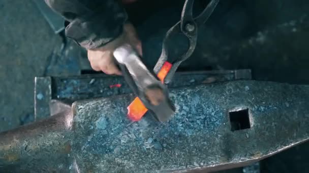 Travailler forgeron frappe un couteau en métal avec un marteau sur l'enclume . — Video