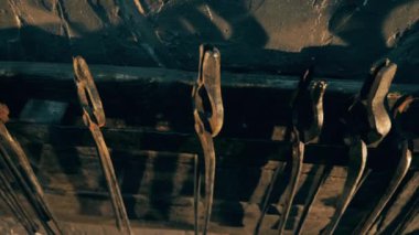 Bir forge bir raf üzerinde asılı metal maşa.