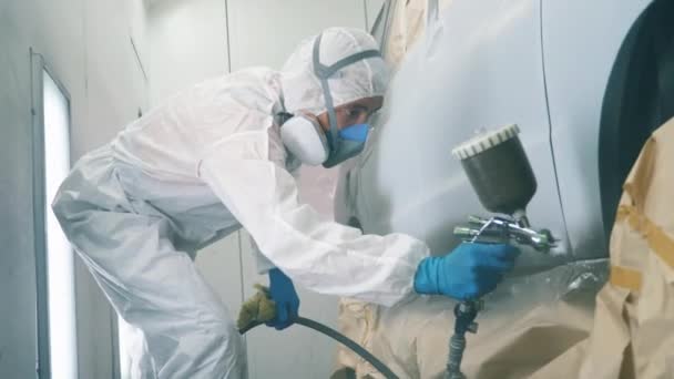 Male worker is colouring the automobile with the paint gun — Stock Video