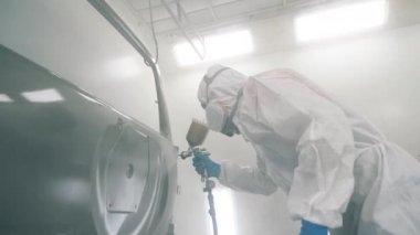 Erkek teknisyen otomobillerin kapılarını boyıyor