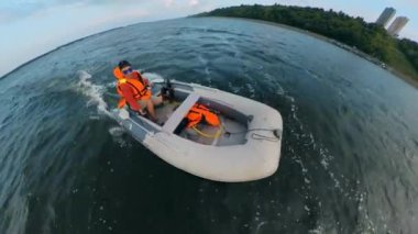 Motorbot bir adam tarafından kıyı boyunca sürülür.