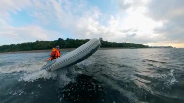 Riverbank boyunca bir motorteknesinde yüzen bir adam ile