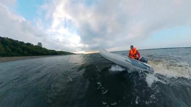 Человек едет на моторной лодке вдоль побережья — стоковое видео