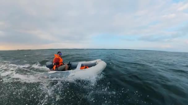 Ein Mann in Schwimmweste fährt auf einem Motorboot — Stockvideo