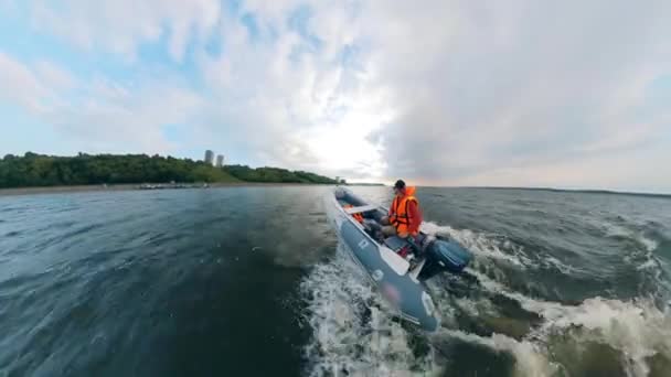 Un homme navigue dans un bateau gonflable le long de la côte — Video
