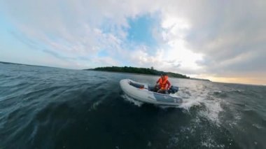 Bir adam nehir boyunca bir motorlu teknede yelken