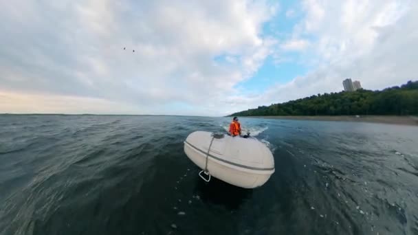 Vooraanzicht van een persoon in een motorboot varen langs de rivier — Stockvideo