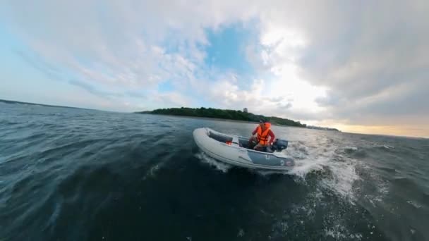 Мужчина плывет на моторной лодке вдоль реки — стоковое видео