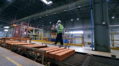 Modern konveyörler ile sanayi tesisinde çalışan meslektaşları.