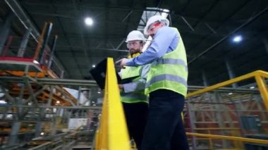 İki mühendis robotik ekipman ile modern fabrikada bir tartışma yaşıyor