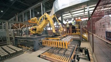Modern fabrikada iki mühendisin kontrolü altında robotik endüstriyel ekipman.