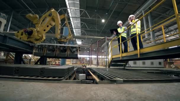 Twee ingenieurs, specialisten beheersen het productieproces bij moderne installaties. — Stockvideo