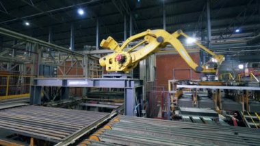 Seramik ürünler fabrikada otomatik robot manipülatör tarafından taşınıyor.