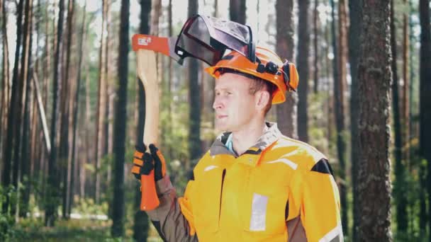 Lumberjack está segurando um machado em seu ombro e olhando ao redor — Vídeo de Stock