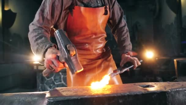 Le métal enflammé se fait marteler par le forgeron. Mouvement lent . — Video
