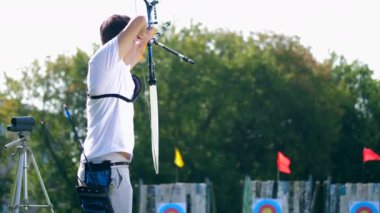 Bir adam bir hedefe saldırır, bir yay vurur..