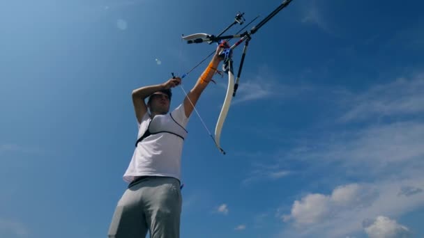 Ein Mann, der mit einem modernen Bogen auf einem Schießstand trainiert. — Stockvideo