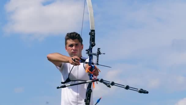 One person pulls an arrow in a bow on a shooting range. — Stock Video