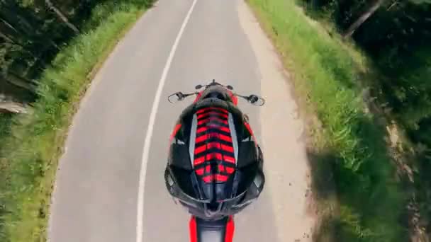 Vista dall'alto del motociclista a cavallo lungo la strada forestale. Motociclo su strada . — Video Stock