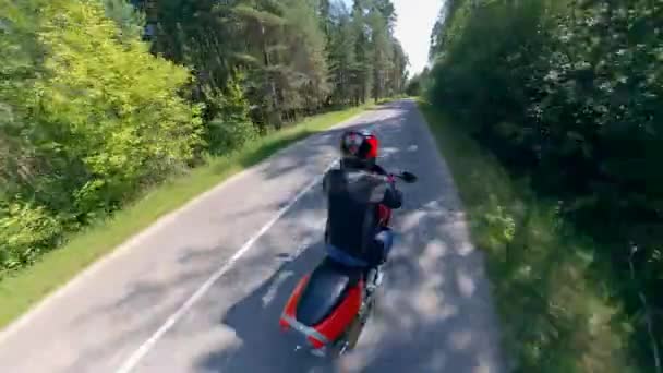 Мотоциклист едет на высокой скорости по дороге — стоковое видео
