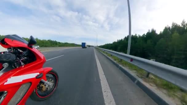 Vista lateral del conductor que monta la motocicleta a lo largo de la carretera. Motocicleta en una carretera . — Vídeos de Stock