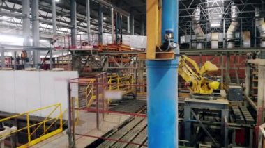 Endüstriyel otomatik makine, endüstriyel bir tesiste kutuları taşır.
