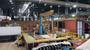 Robotik kol bir fabrikada ekipman kaldırır.