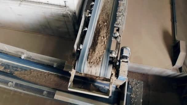 Pietre con sabbia che salgono su un trasportatore in una fabbrica . — Video Stock