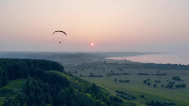 Parasailing vehicle is floating across the sunset horizon — Stock Video
