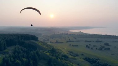 Gün batımı manzara ve paraplane uçan bir kişi