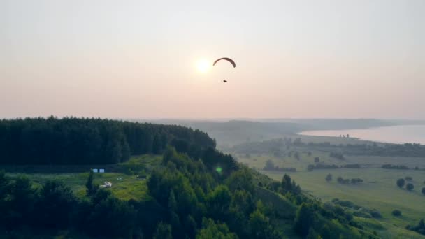 Dimmiga fält med Paraglider som flyter över dem — Stockvideo