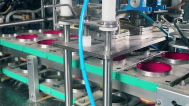 Fabrika makinesi plastik kutuları nyerini değiştirip dolduruyor. Fabrikada paketleme işlemi.