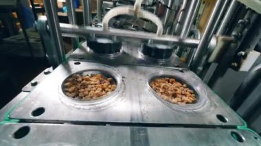 Fabrika makinesi ekmek kırıntılarını folyoyla kaplar. Fabrikada paketleme işlemi.