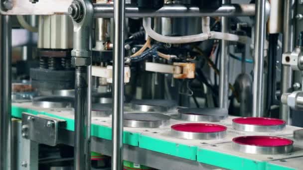 Metalen machine is het sluiten van bewegende containers met folie. Verpakkingsproces in de fabriek. — Stockvideo