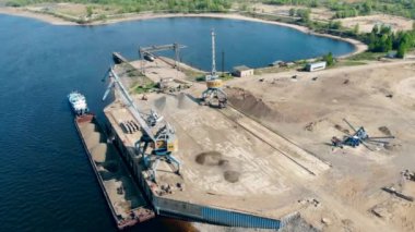 Bir vinç limanda çalışırken bir mavna dan ezilmiş taşlar alır.