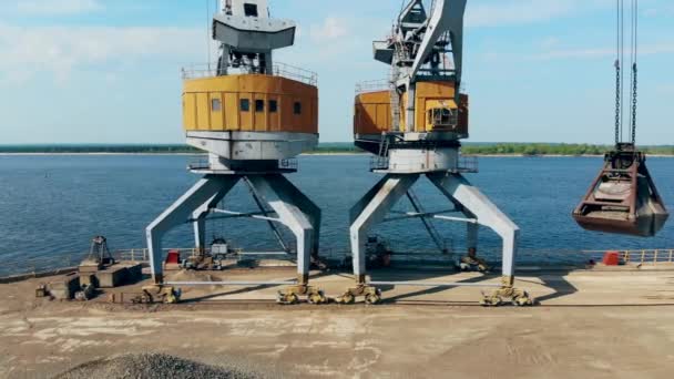 Gele kraan giet breuk stenen in een stapel tijdens het werken bij Docks. — Stockvideo