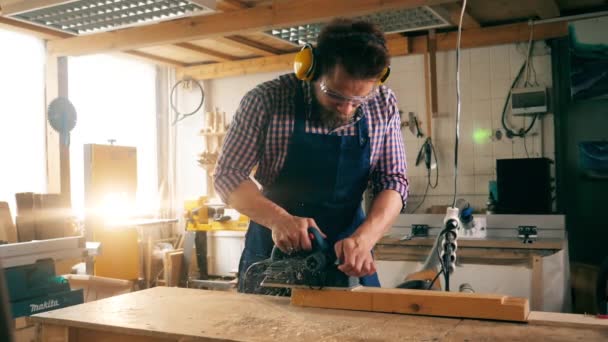 Un pedazo de madera está siendo aserrado por el artesano en cámara lenta — Vídeos de Stock