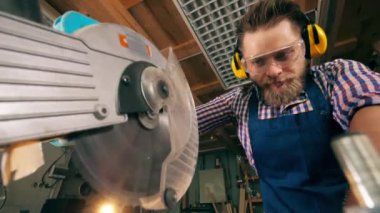 Erkek marangoz yavaş çekimde döner testere ile odun testere