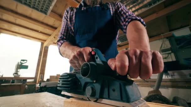 Movimiento lento de un bloque de madera siendo cortado por el carpintero — Vídeos de Stock